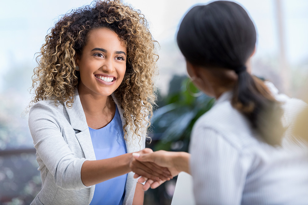 Young professional women shaking hands