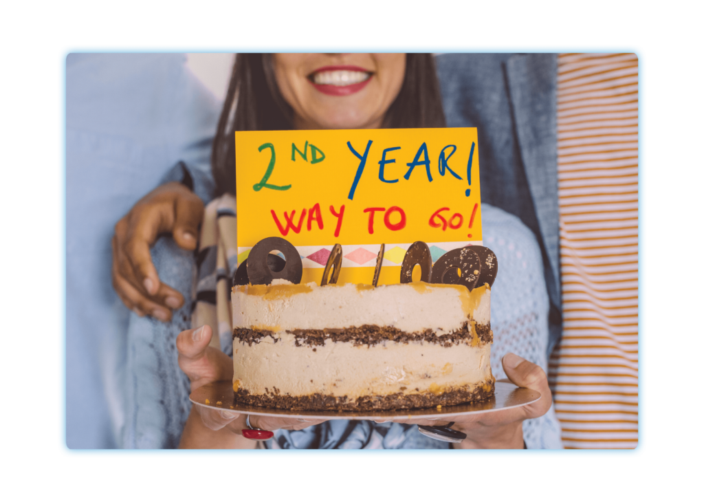 Woman holding a cake to celebrate work milestone