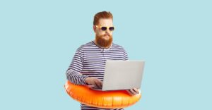 Man in summer attire wearing sunglasses and a swim ring, working on a laptop.