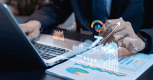 Business professional analyzing long-term incentive (LTI) strategy data on a laptop, with digital charts, performance metrics, and growth projections overlaid to illustrate compensation planning and reward modeling.